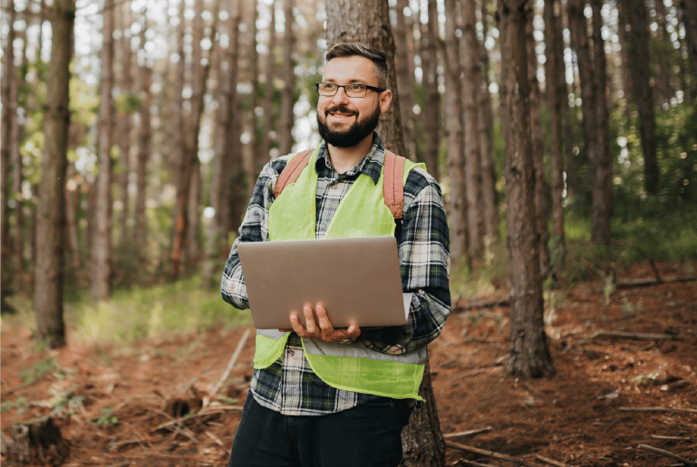 man on laptop in forest